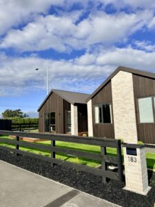 Black post-and-rail fence with planting in Christchurch