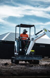 SK Civil crew member operating a mini digger on a new-build site prep