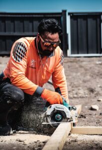 SK Civil crew member cutting timber on site