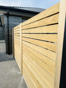 Horizontal timber slat privacy screen with black mulch garden bed