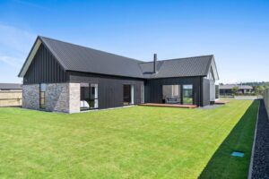 New-build lawn and hardwood deck, dark cladding home