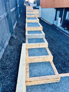 Timber steps and gravel path with mulched garden beds